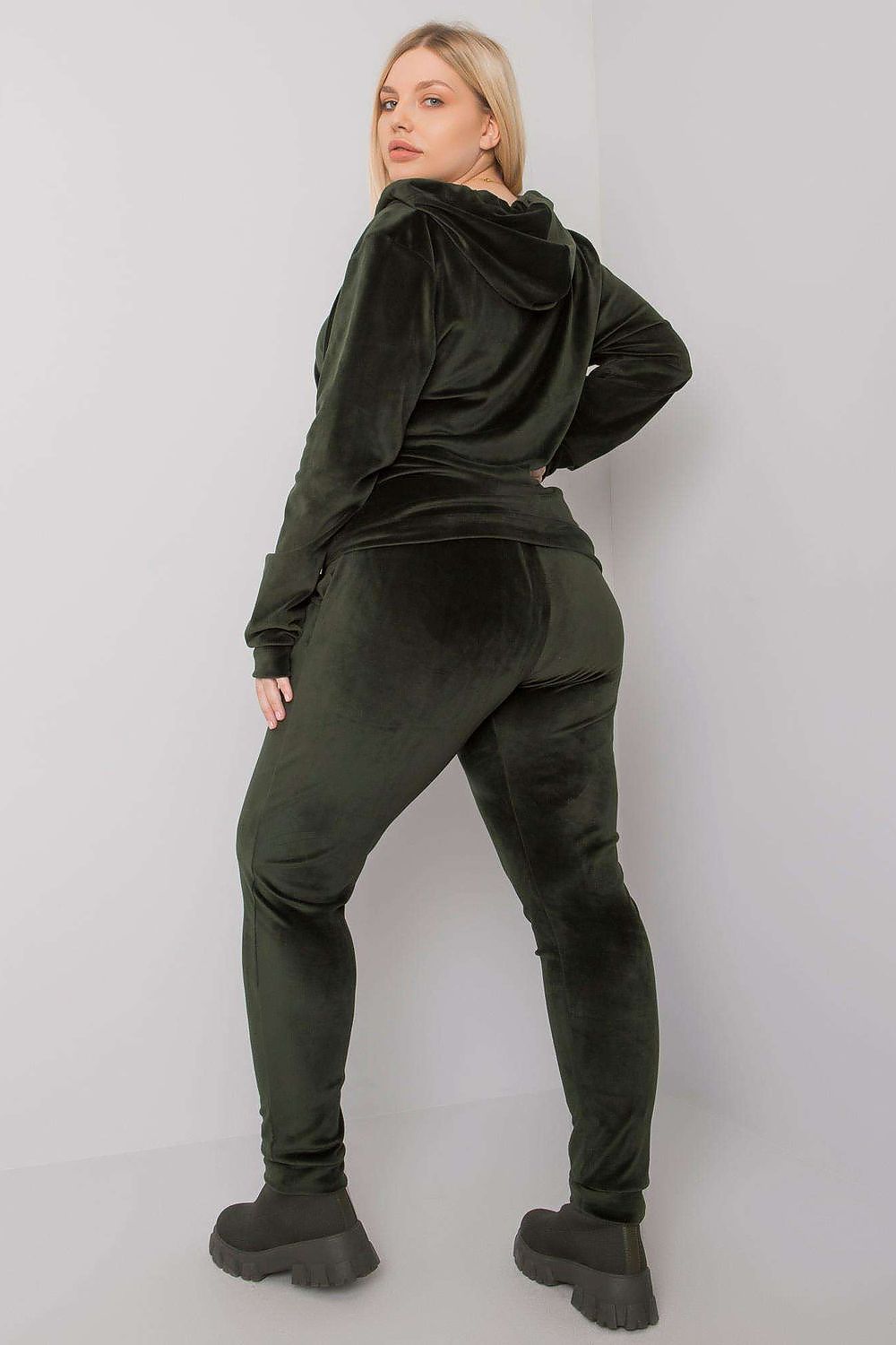 Person wearing a green tracksuit against a white background