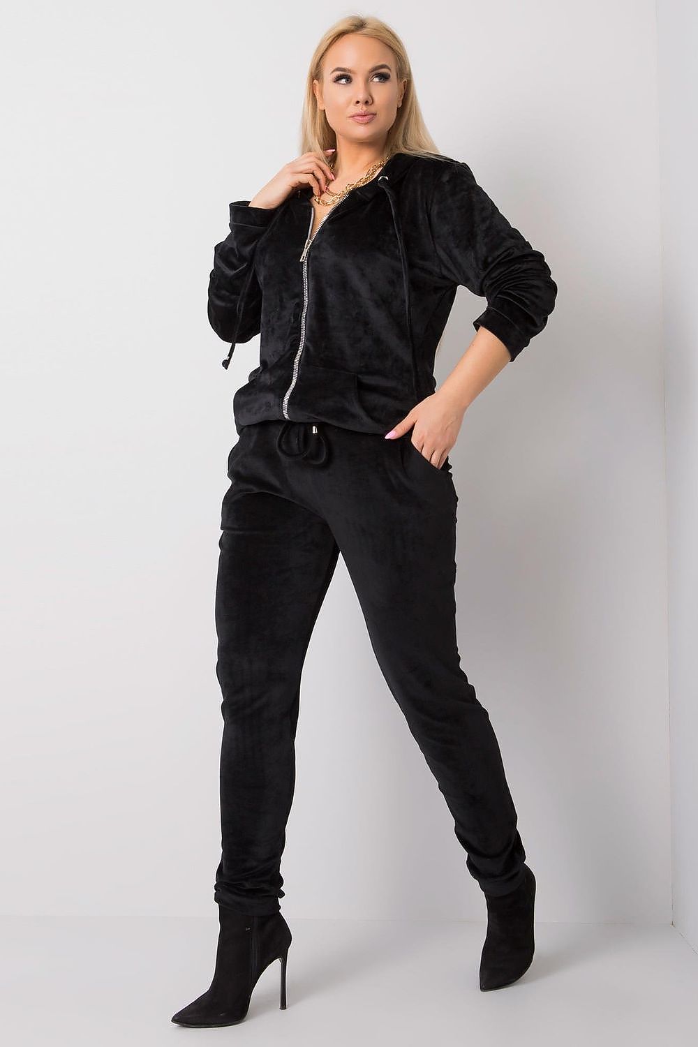 Woman wearing a black tracksuit against a white background