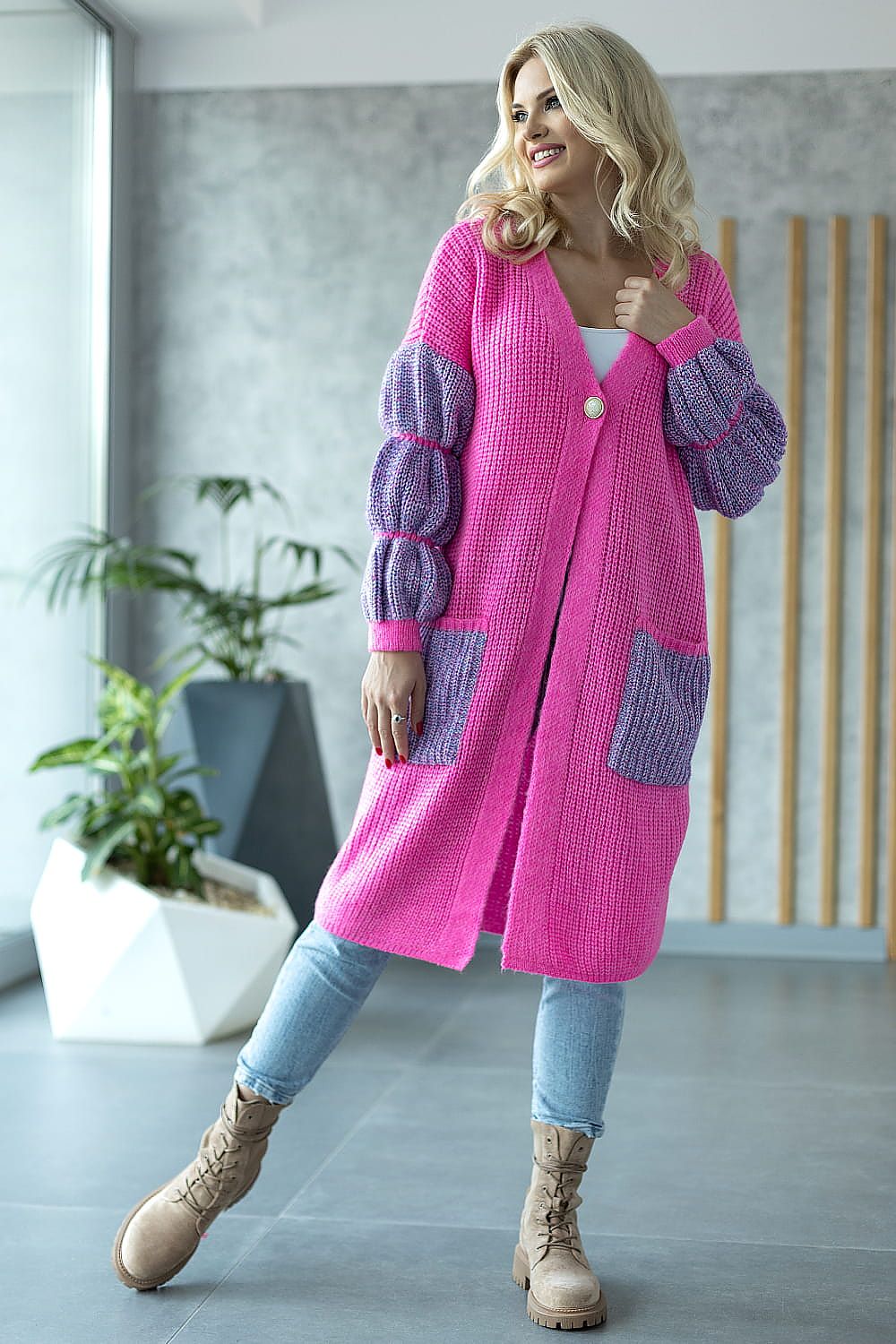 Woman wearing a pink and purple cardigan in an indoor setting