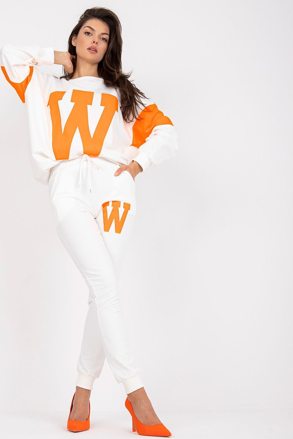 Woman wearing a white outfit with orange accents on a white background