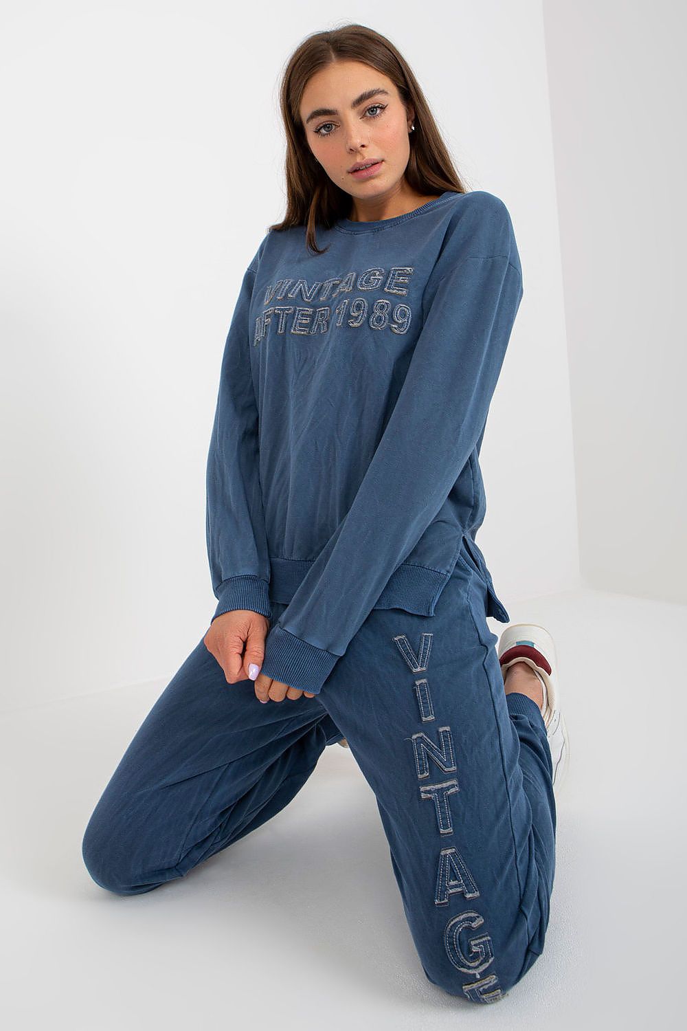 Woman wearing a blue tracksuit with 'Vintage After 1989' text on a white background