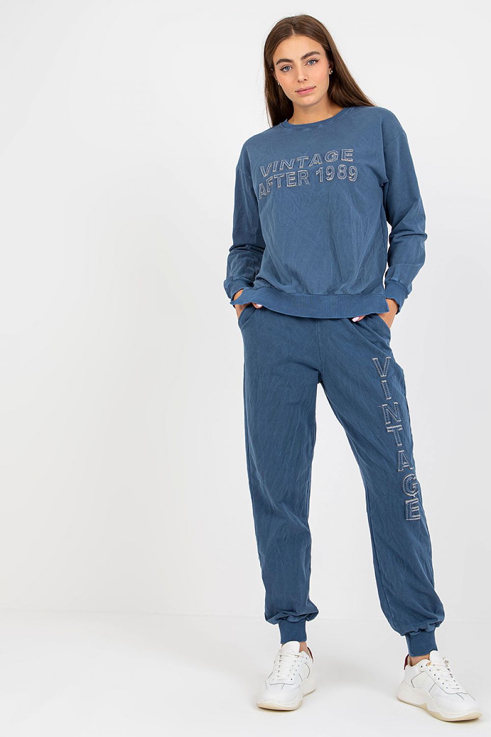 Woman wearing a blue tracksuit with text on a white background