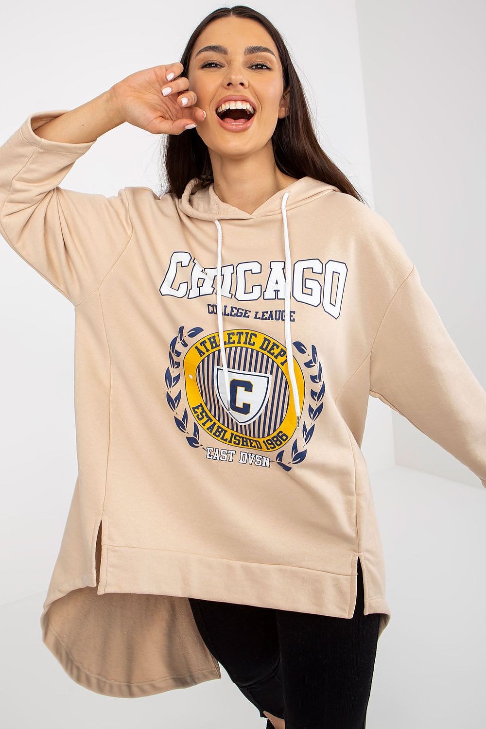Woman wearing a beige hoodie with 'Chicago' and athletic design on a white background