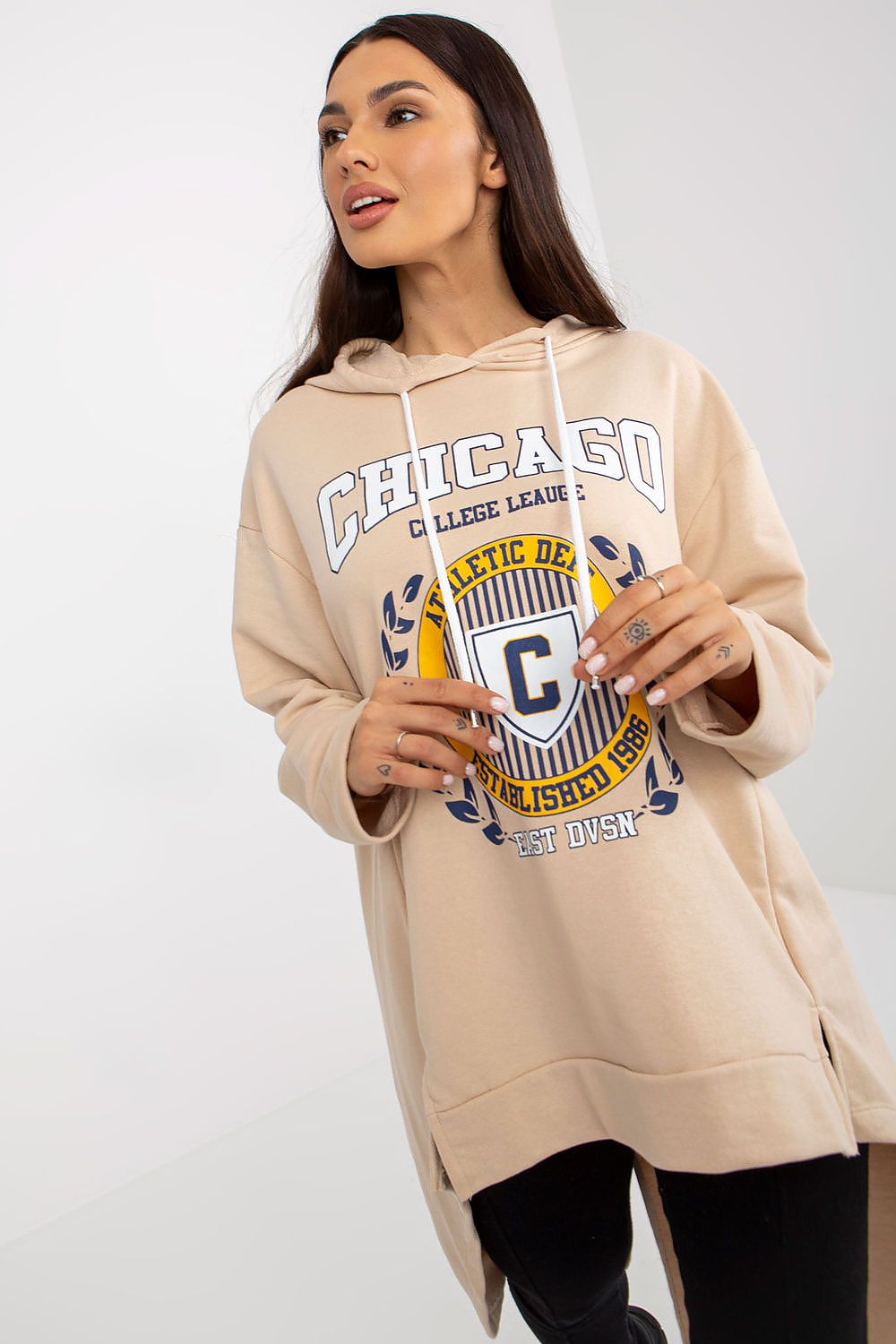 Woman wearing a beige hoodie with 'Chicago' text and graphics on a white background