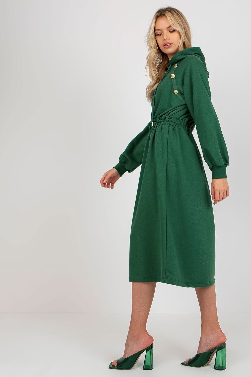 Woman wearing a green dress with buttons on a white background