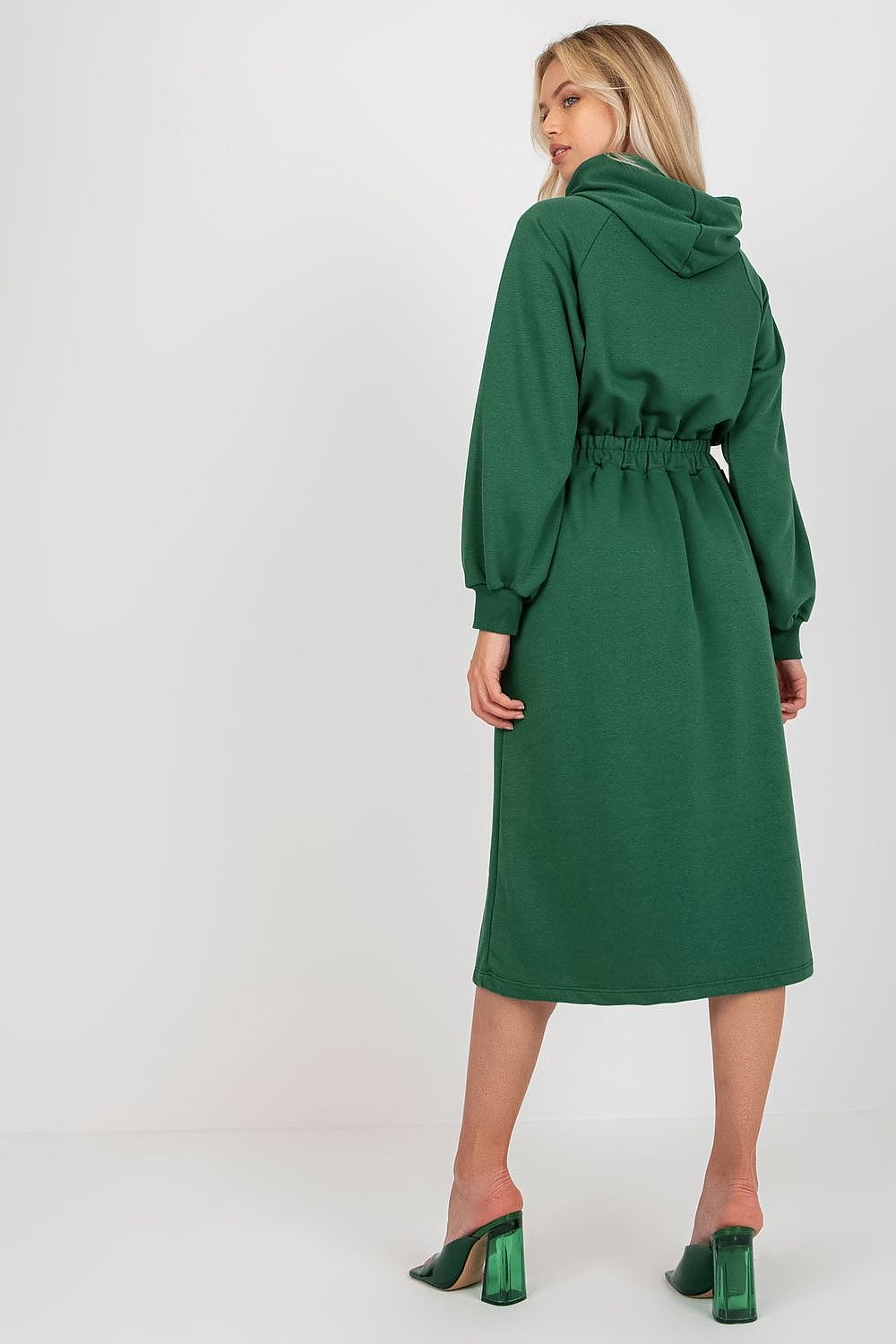 Woman wearing a green dress with a hood on a white background