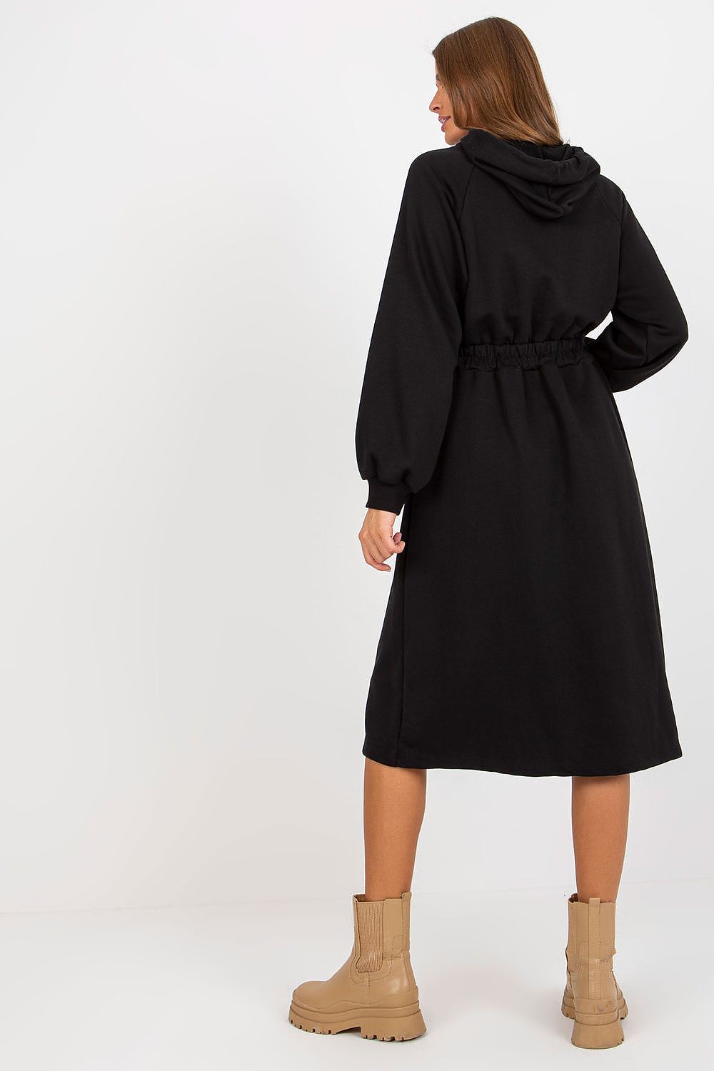 Woman wearing a black coat with a hood on a white background