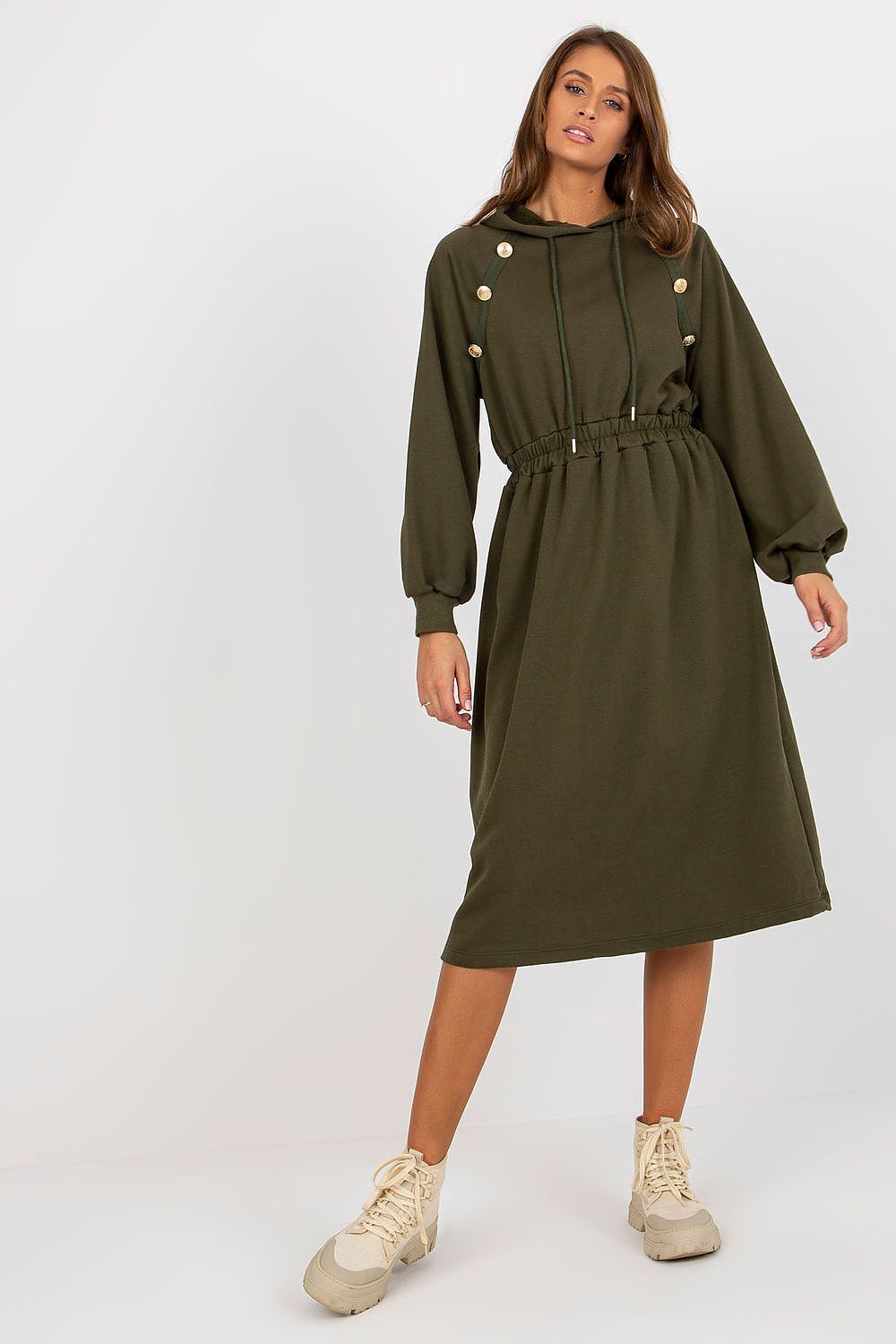 Woman wearing a green dress with buttons on a white background