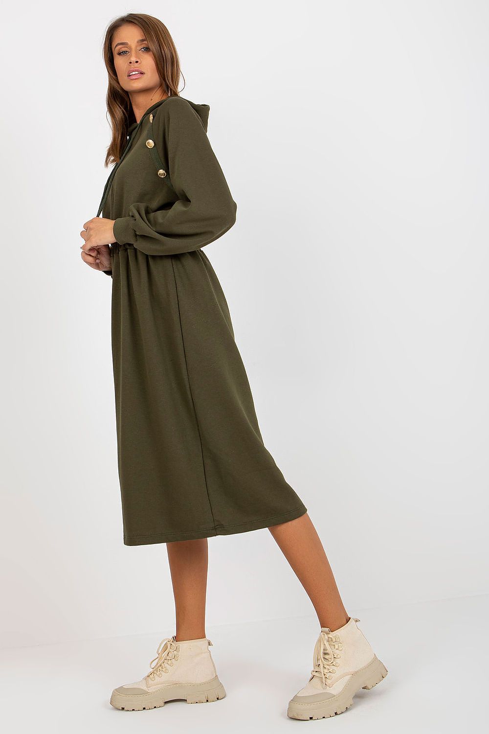Woman wearing a green dress with a belt on a white background