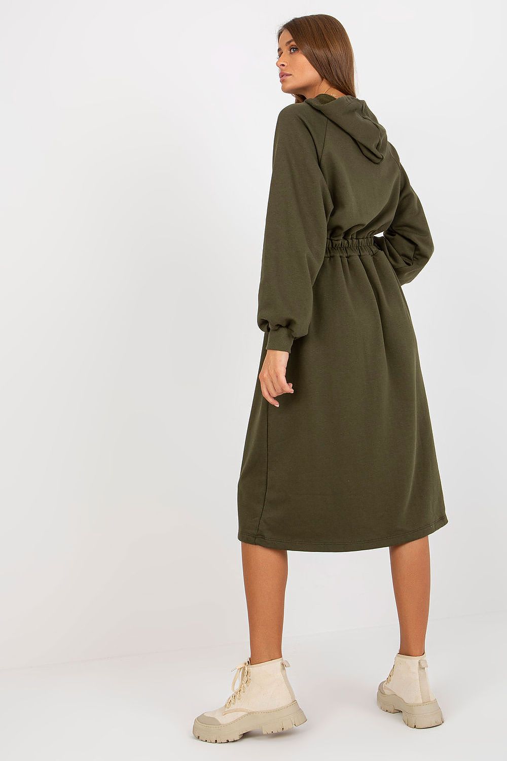 Woman wearing a green hooded dress on a white background