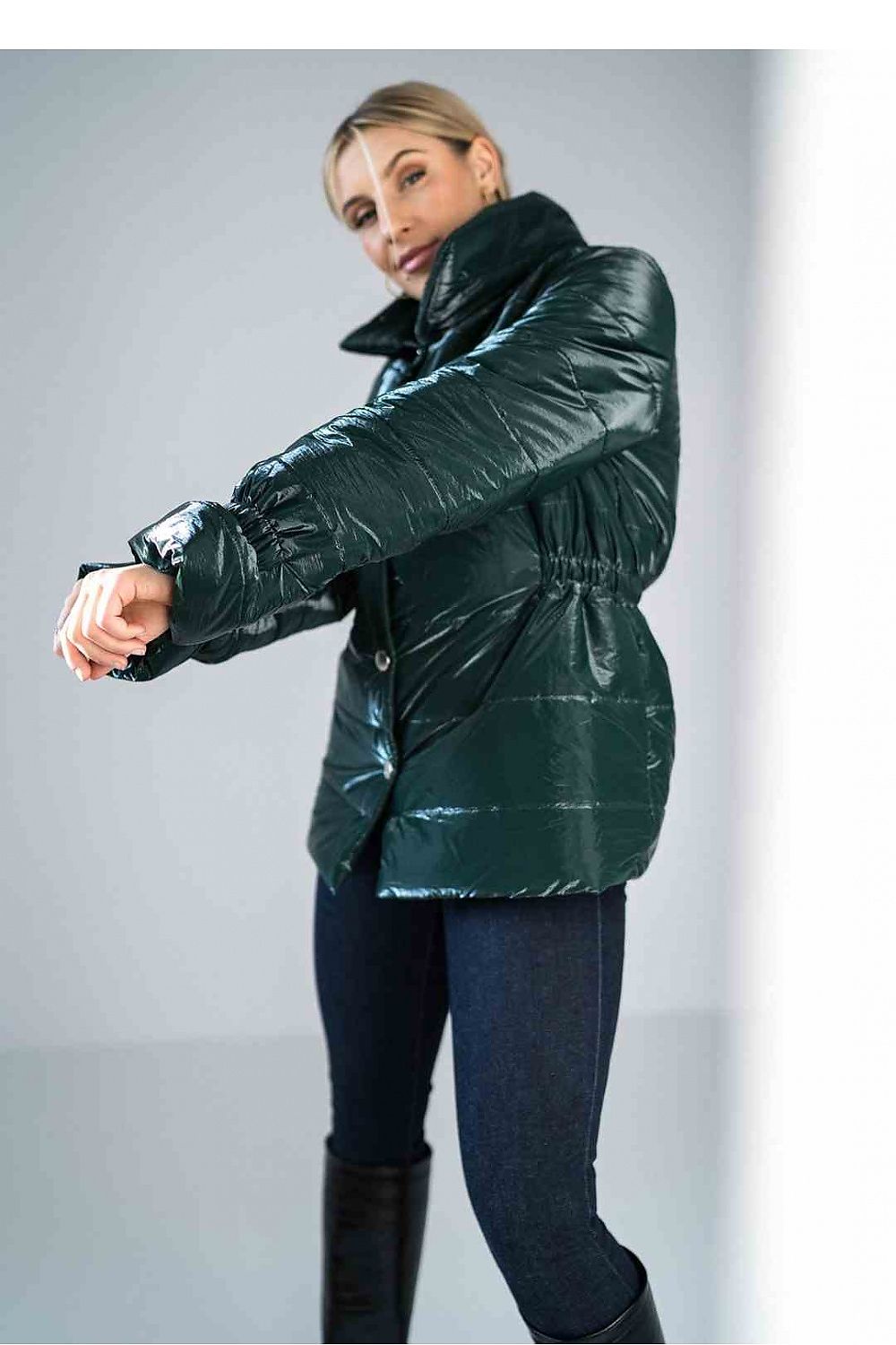 Woman wearing a green puffer jacket against a gray background