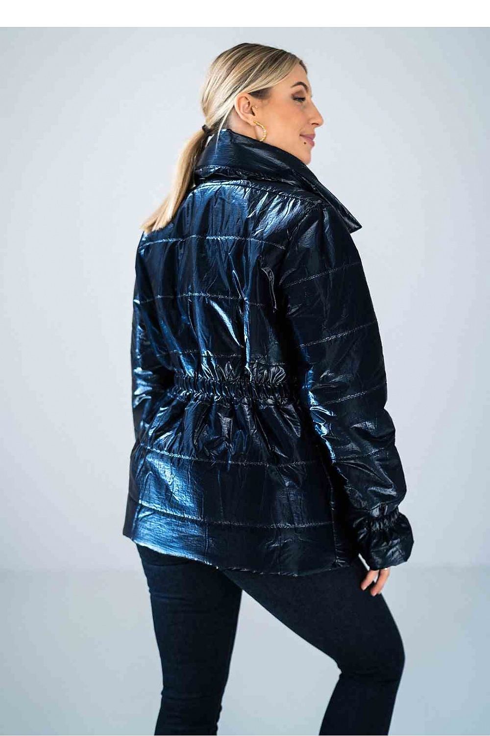 Woman wearing a shiny blue jacket against a white background