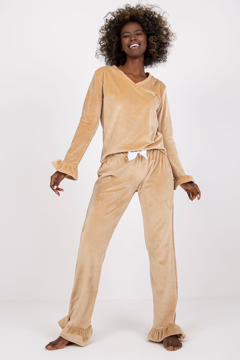 Woman wearing a beige velvet outfit on a white background