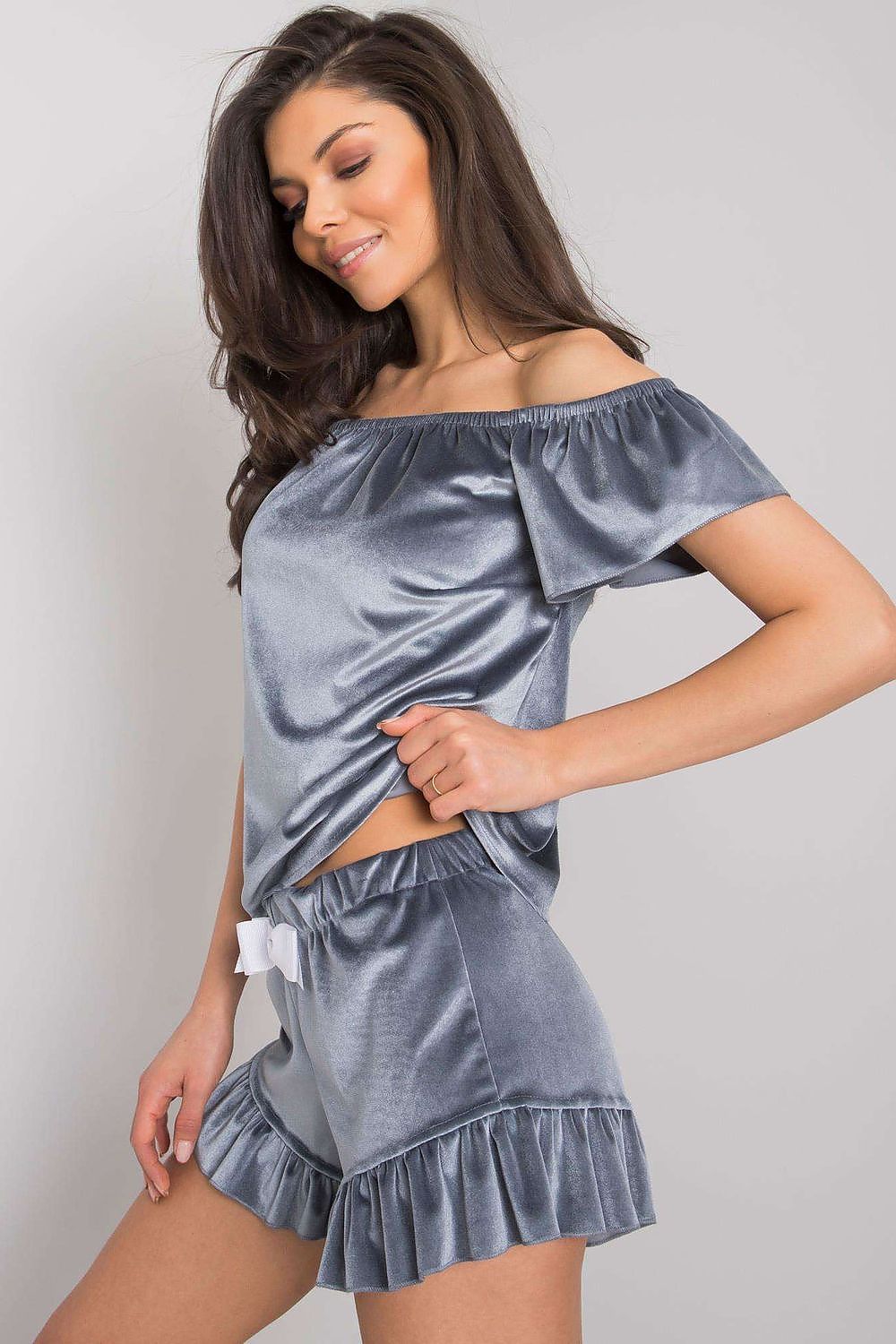 Woman wearing a gray satin off-shoulder top and shorts set on a plain background