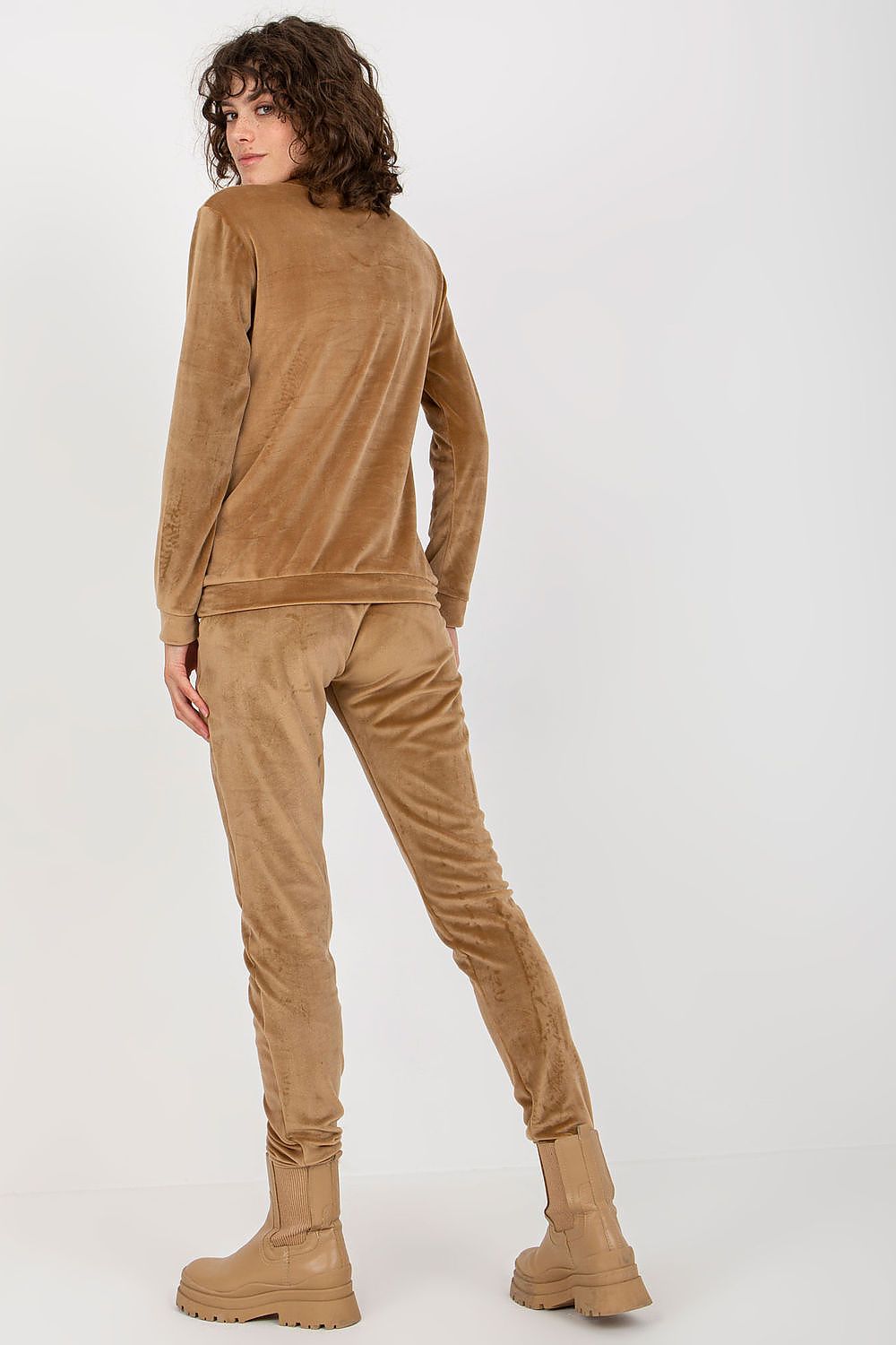 Person wearing a brown outfit with a matching top and pants on a white background
