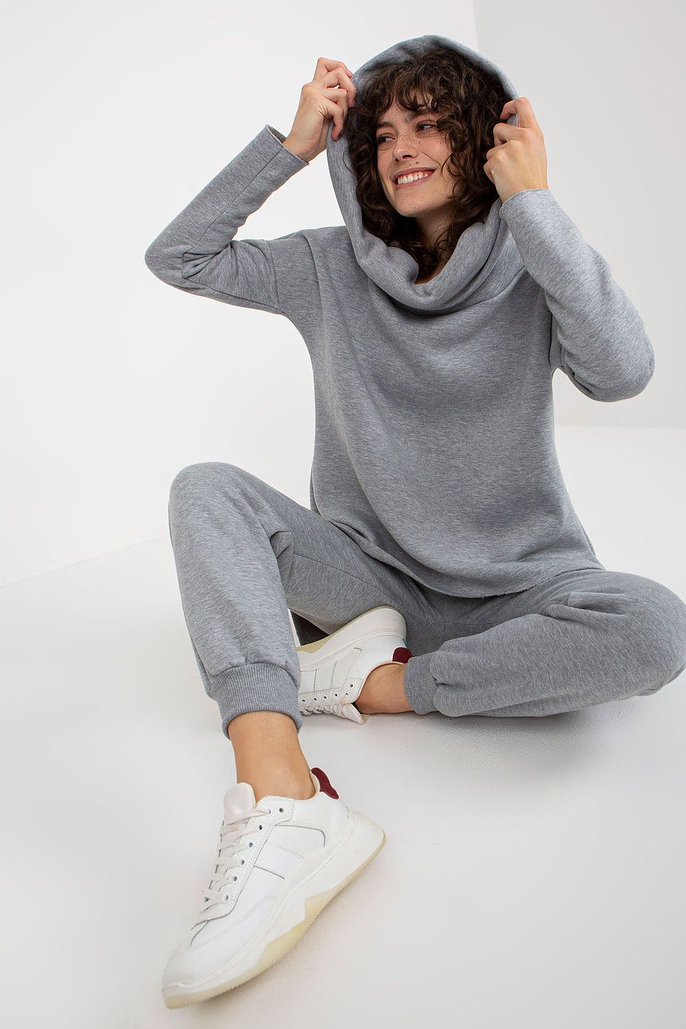  Close-up of beige hooded sweatshirt with pocket and drawstring detail