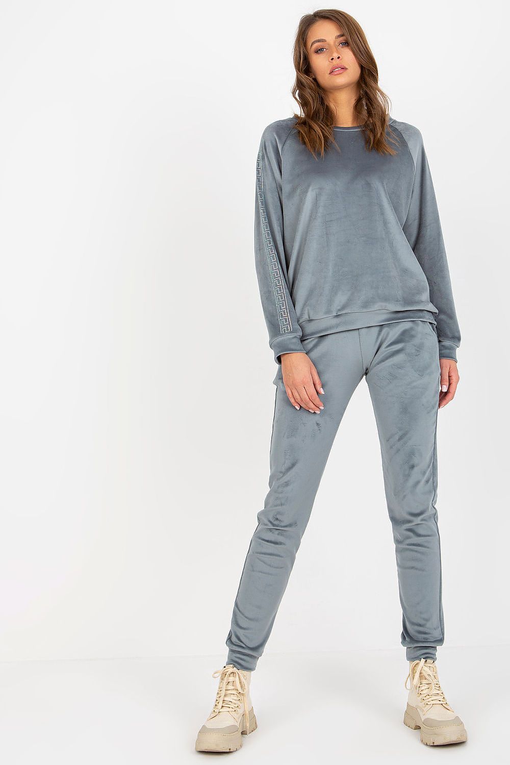 Woman wearing a gray tracksuit on a white background