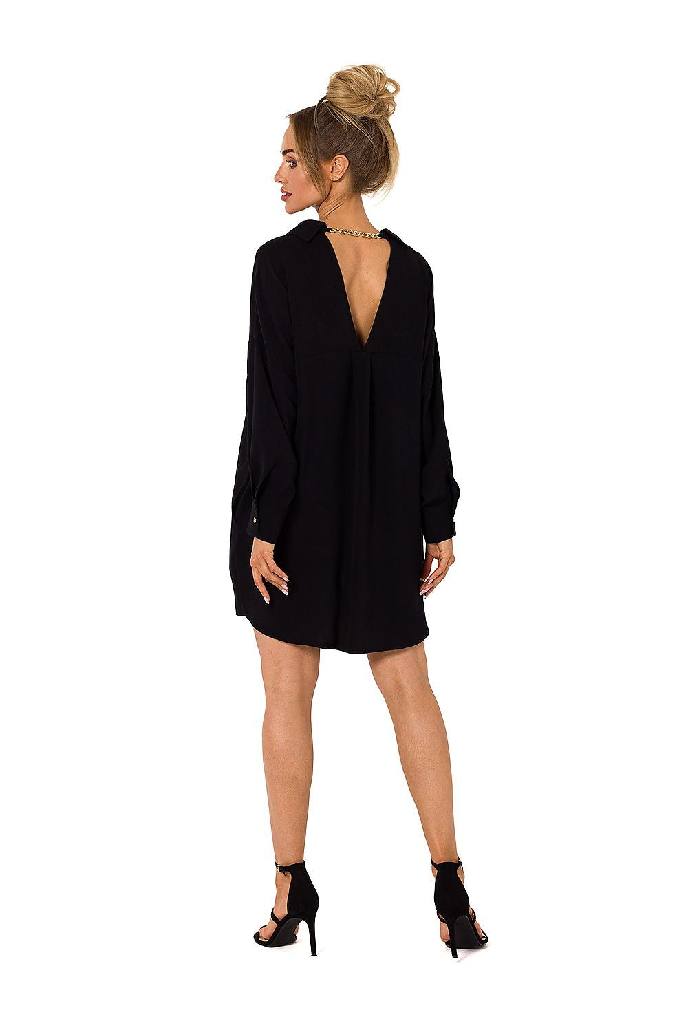 Woman wearing a black dress with a deep neckline on a white background