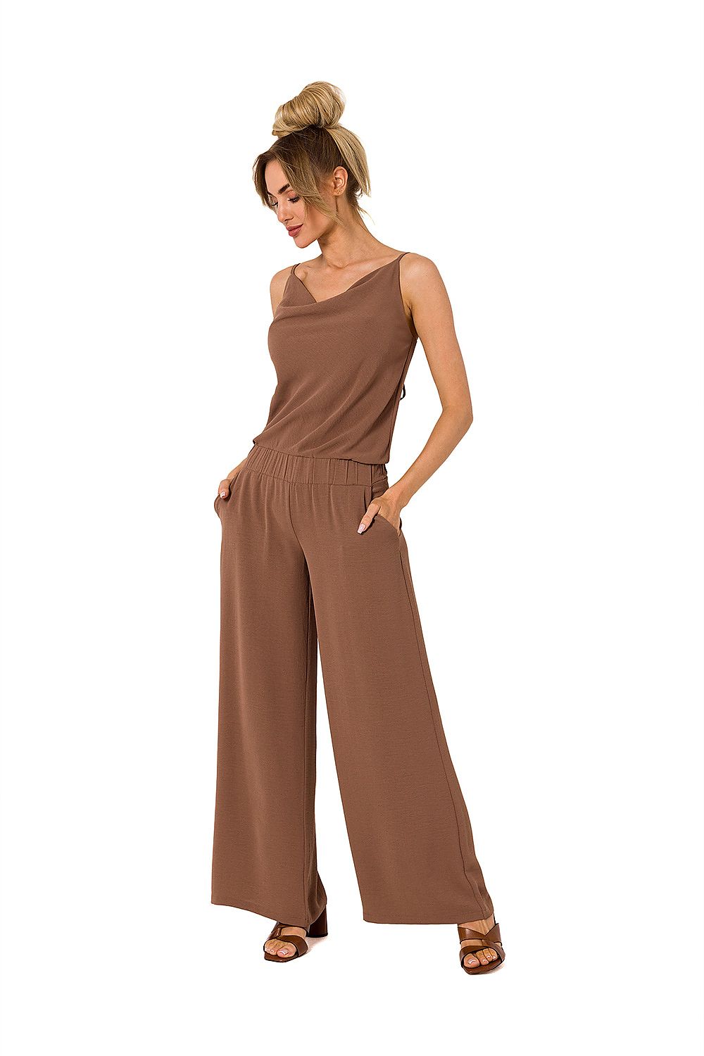 Woman wearing a brown jumpsuit on a white background