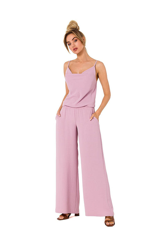 Woman wearing a pink jumpsuit on a white background