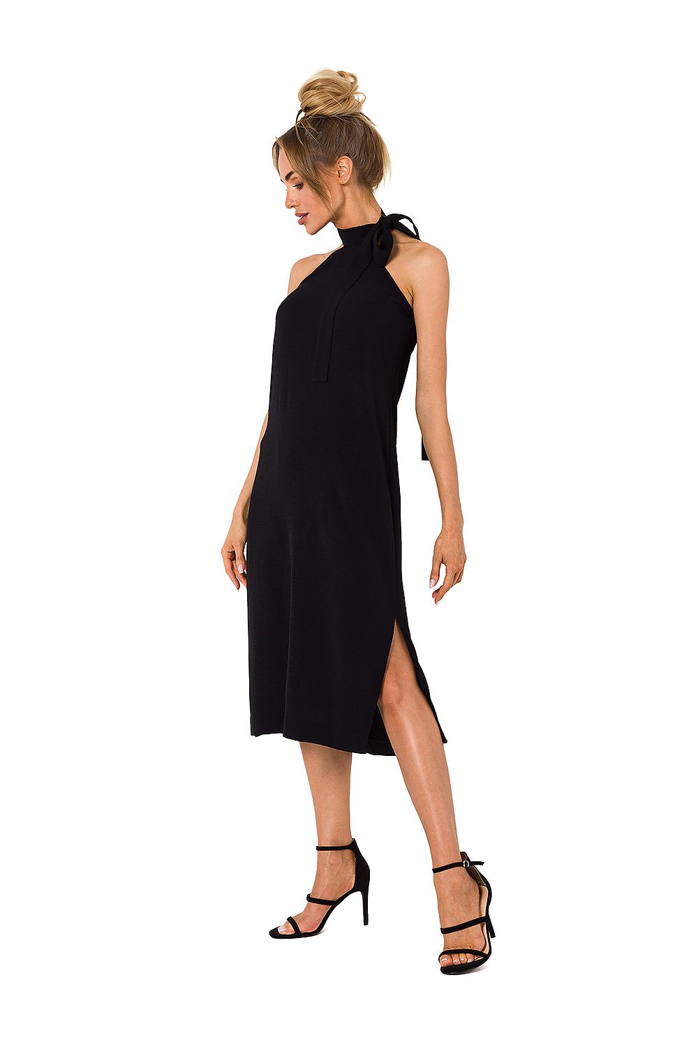 Woman wearing a black halter neck dress with a slit on a white background