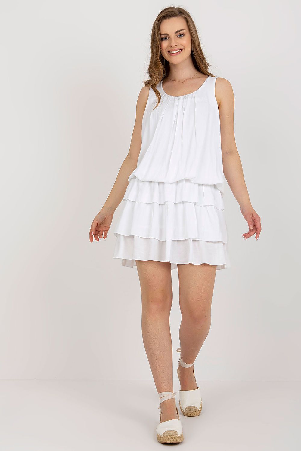 Woman wearing a white dress on a plain background
