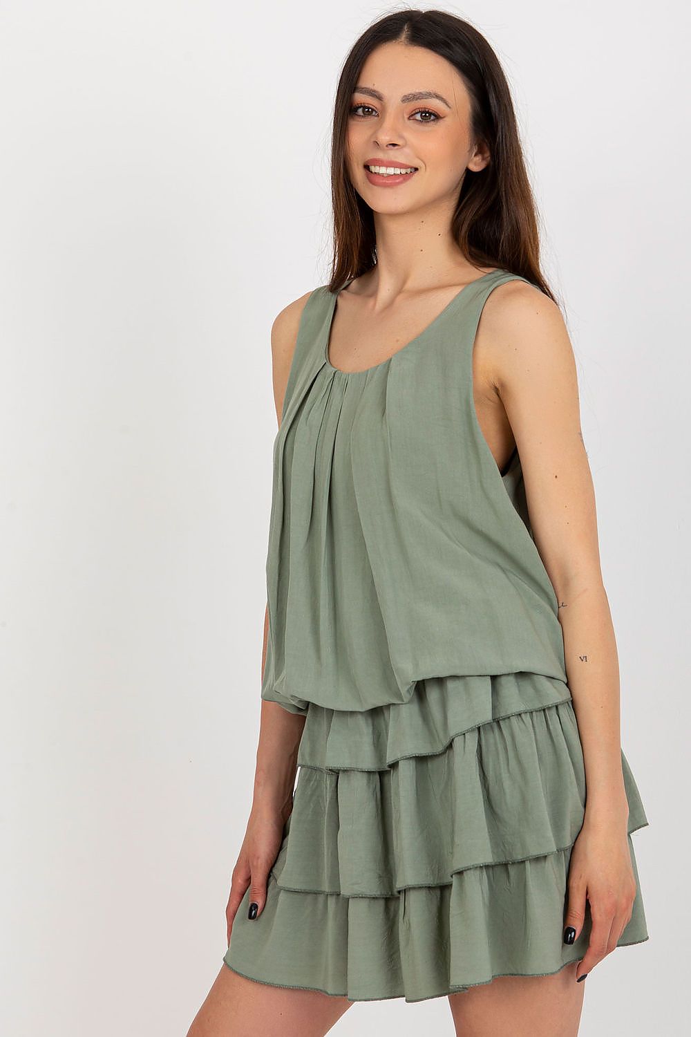 Woman wearing a green dress with layered skirt on a white background