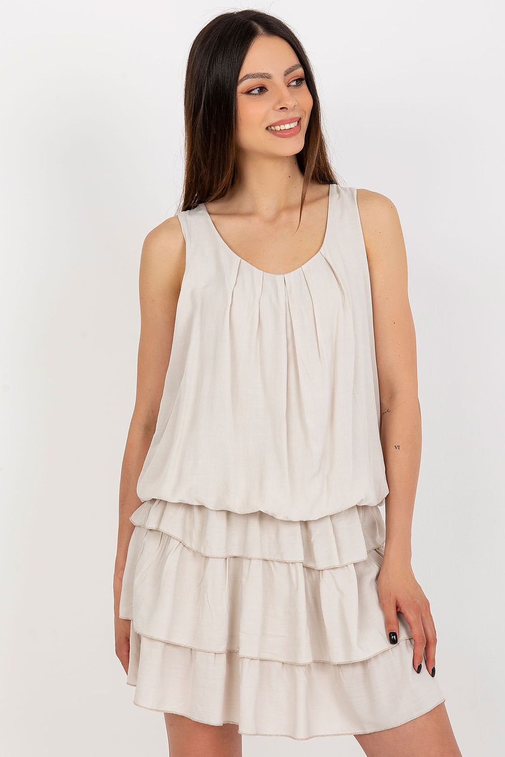 Woman wearing a layered beige dress on a white background