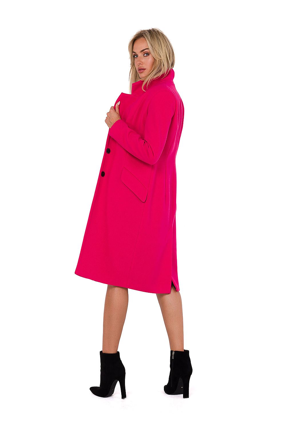 Woman wearing a bright pink coat on a white background