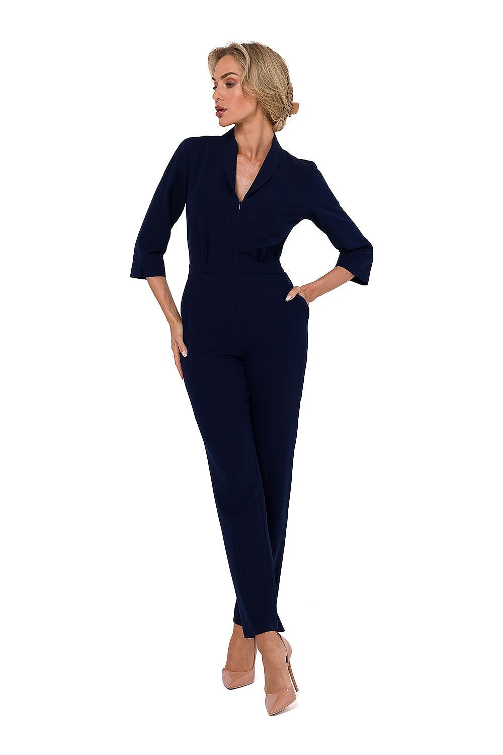 Woman wearing a navy jumpsuit on a white background