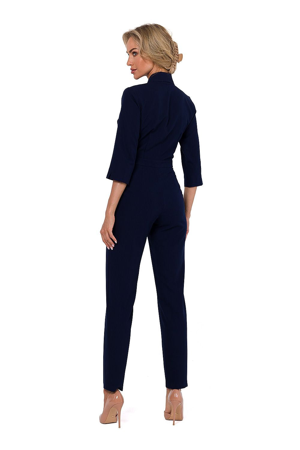 Woman wearing a navy blue jumpsuit on a white background