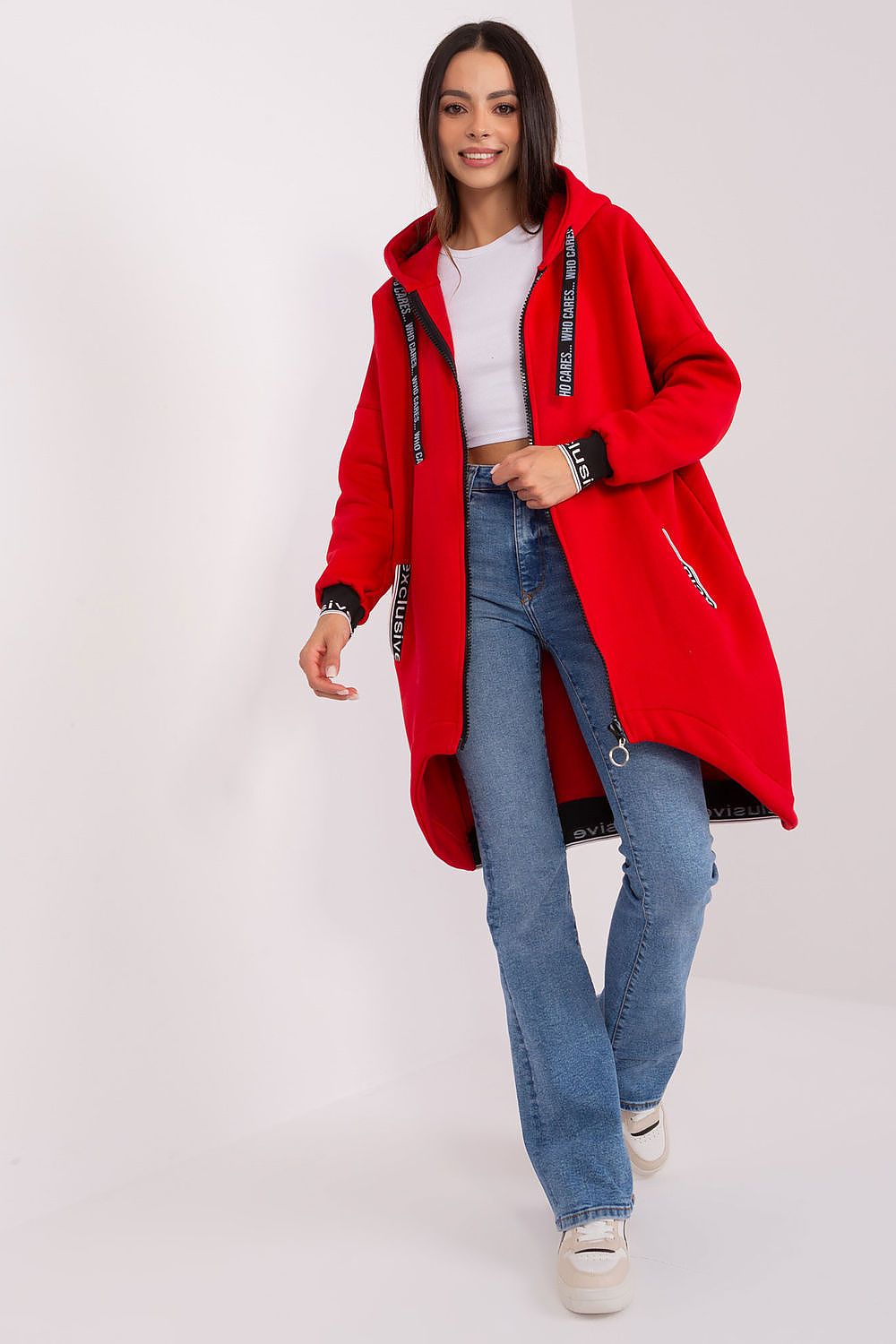 Woman wearing a red coat, white shirt, and blue jeans on a white background