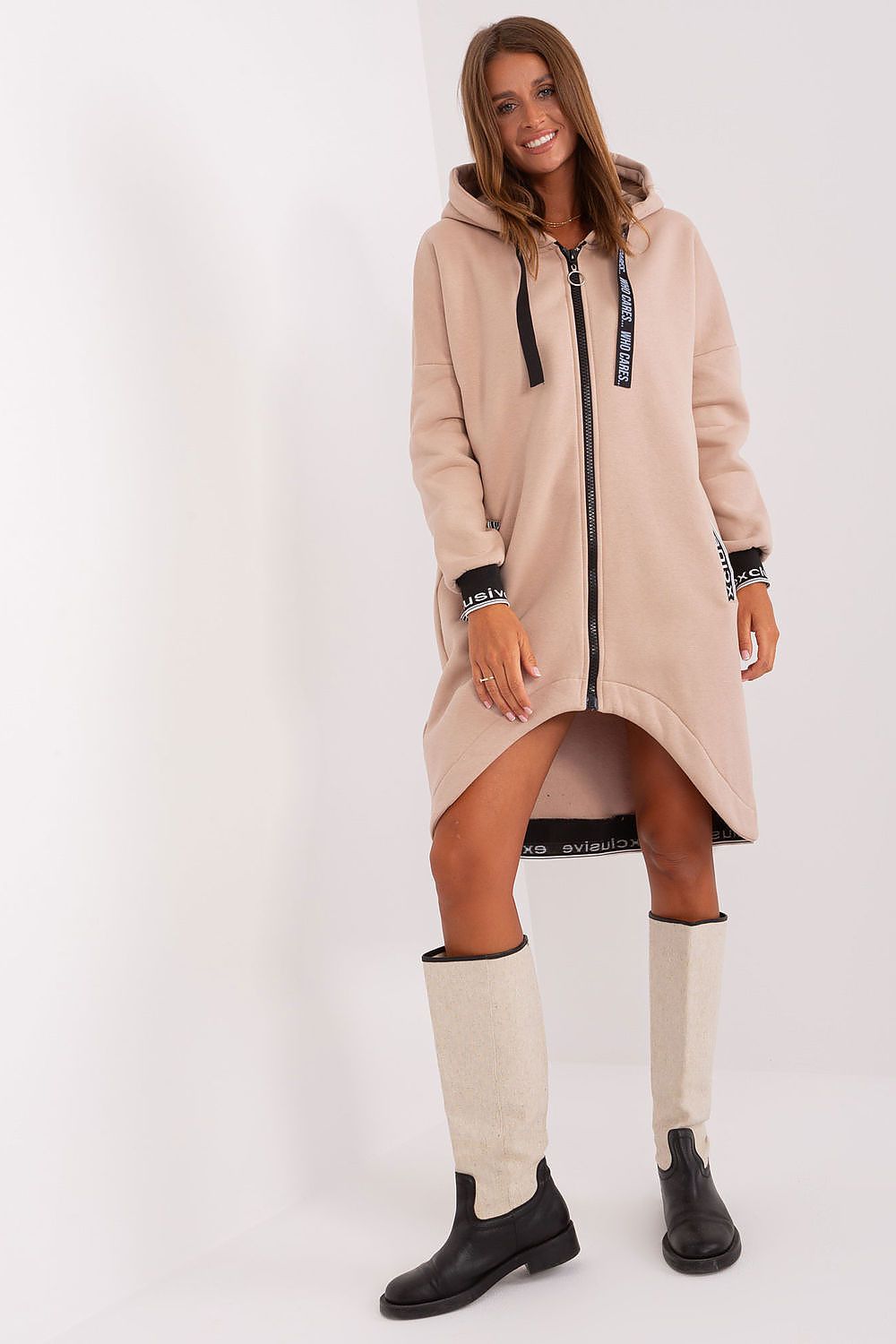 Woman wearing a beige hooded coat and knee-high boots on a white background