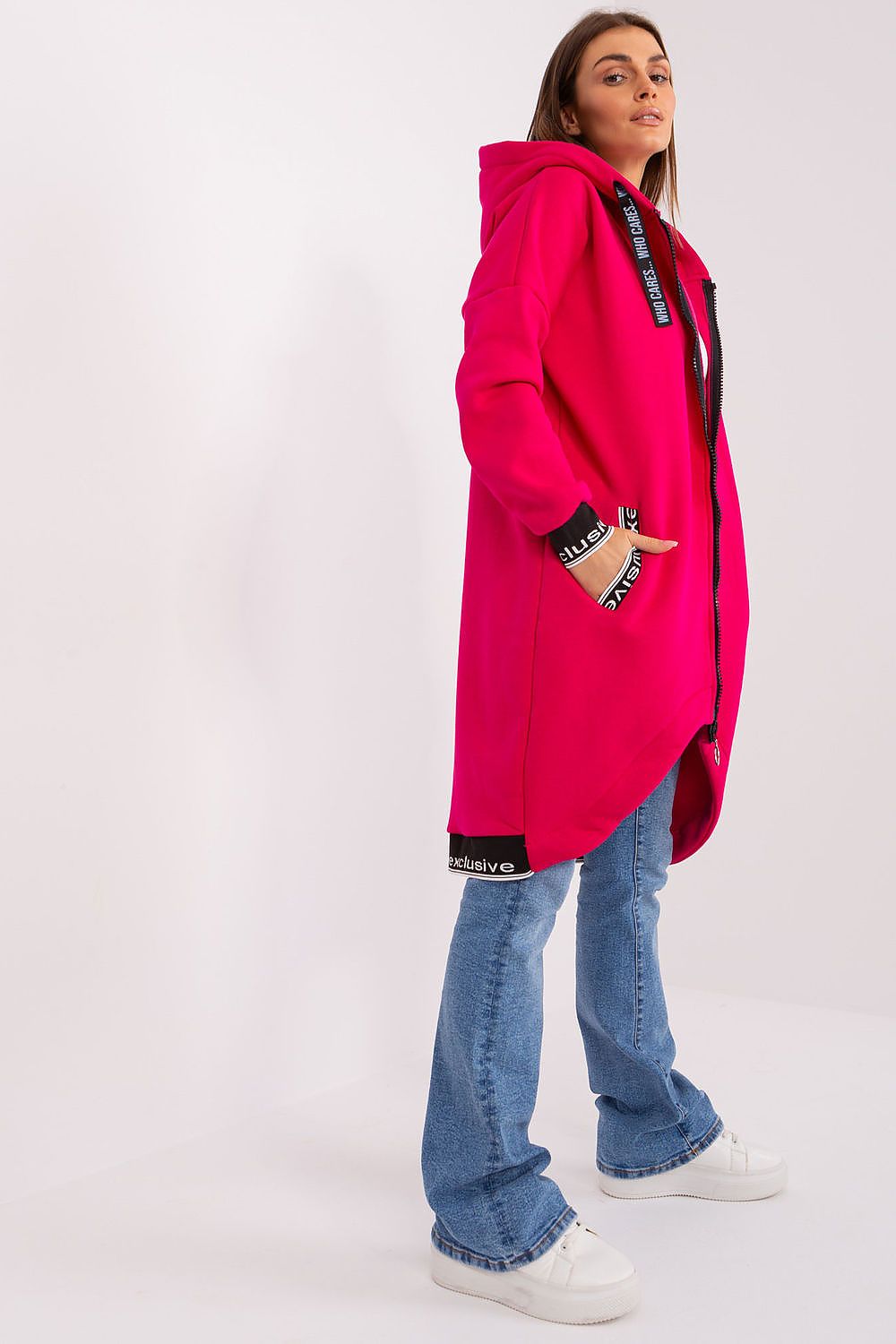 Person wearing a bright pink coat with black accents on a white background