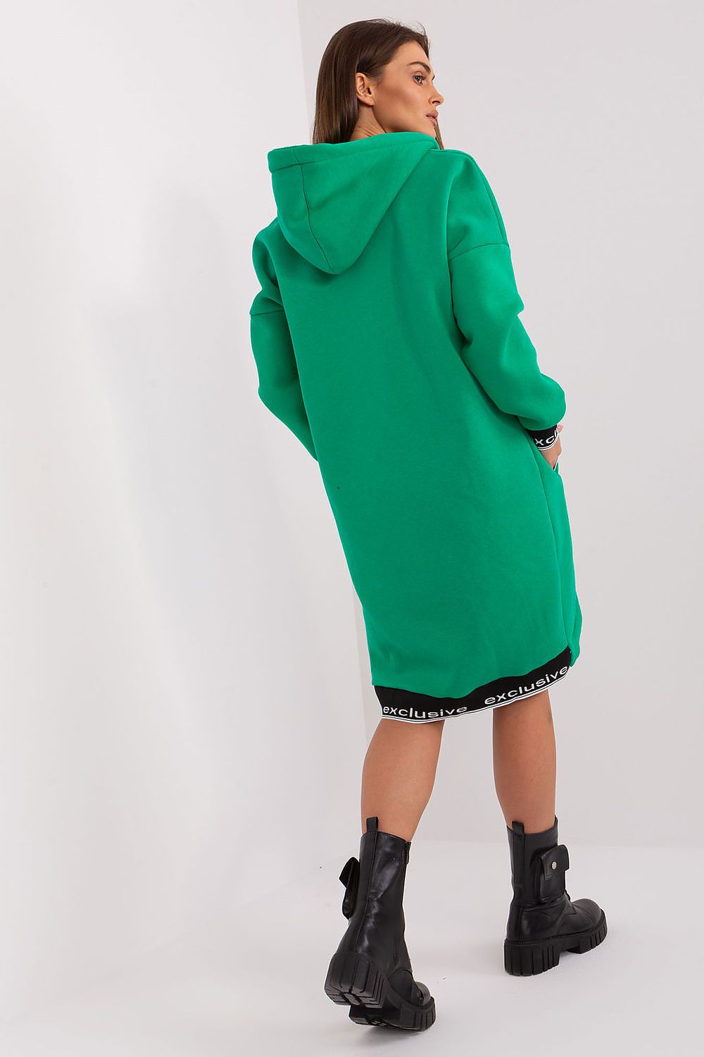 Woman wearing a green hoodie dress on a white background