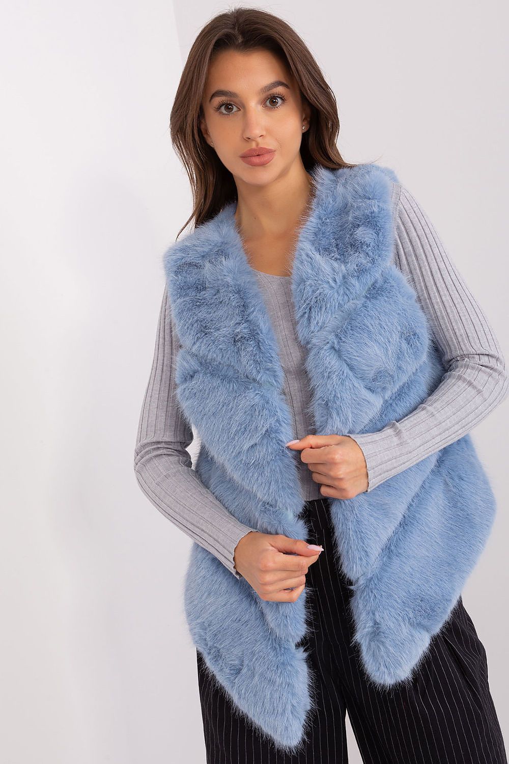 Woman wearing a light blue fur vest on a white background