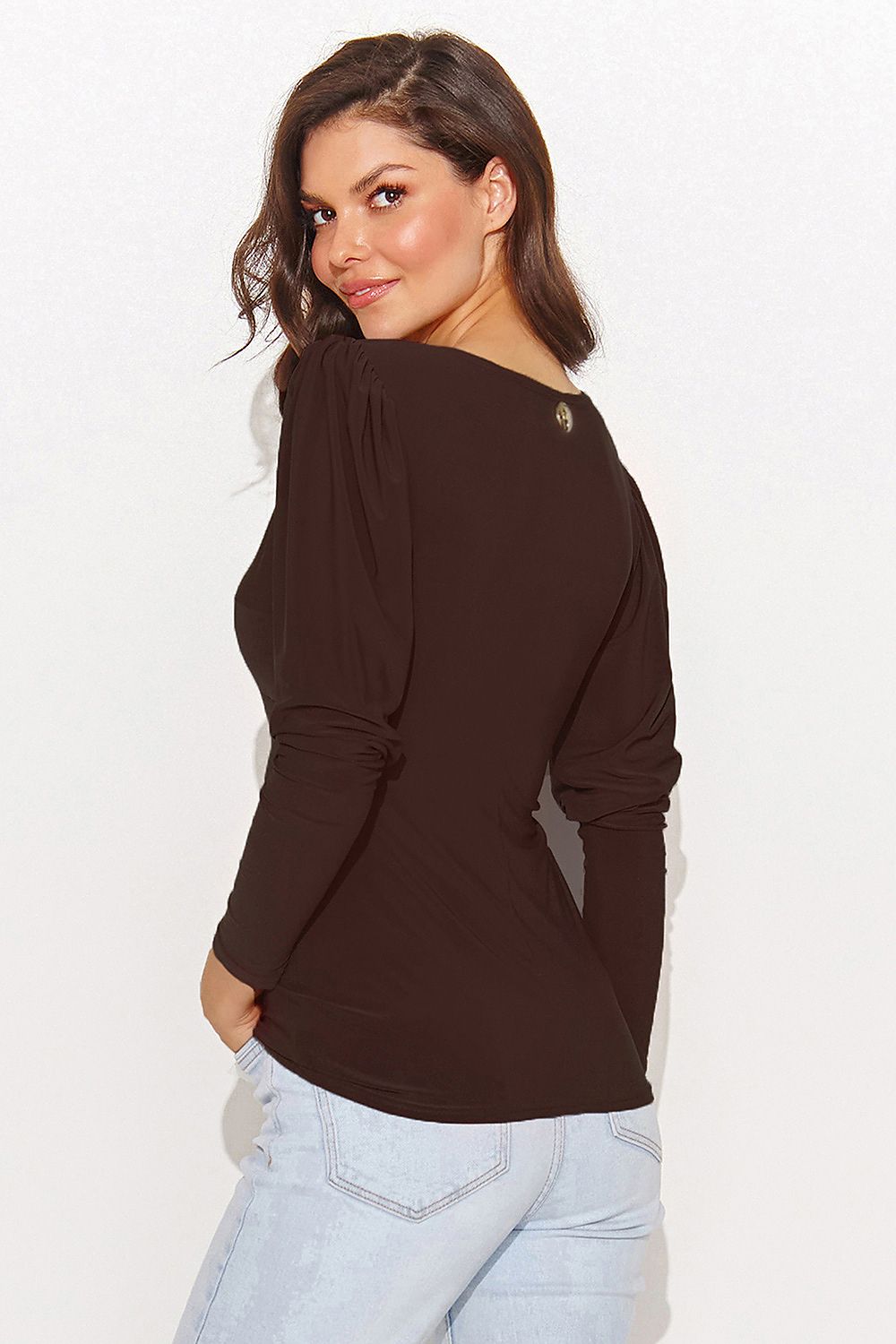 Woman wearing a brown long-sleeve top with a knot detail on a white background