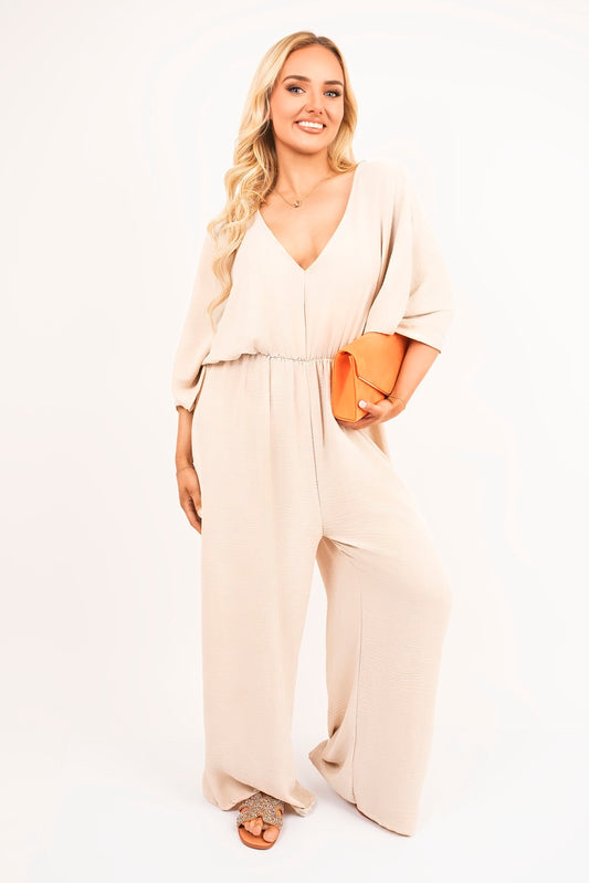 Beige: “Wide leg V-neck jumpsuit in beige with back tie detail, front view”