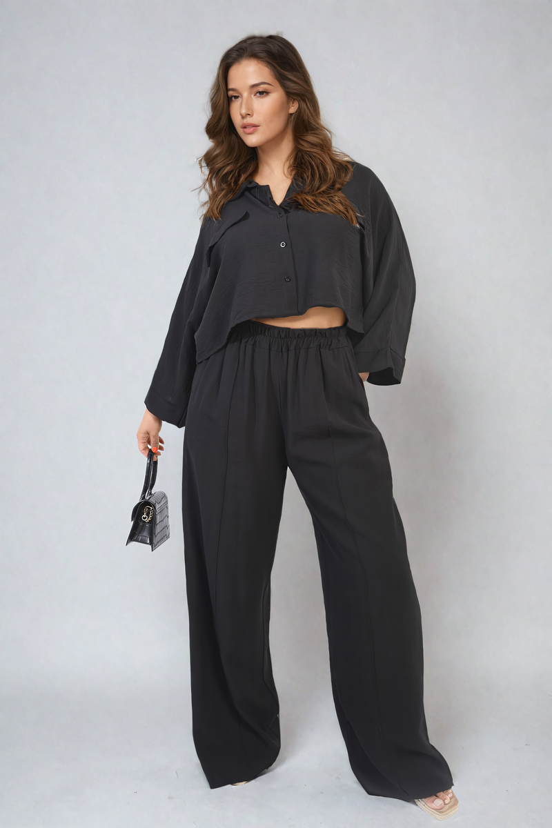 Back view of black crop top & trousers set highlighting oversized top.