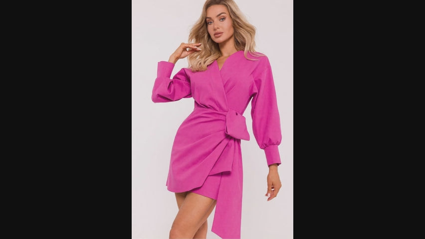 Load video: Women wearing a rich pink, wrap mini dress with an asymmetrical hemline and long sleeves